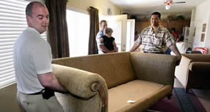 Professional moving services with guaranteed flat rate quotes - experienced movers loading furniture for residential moving